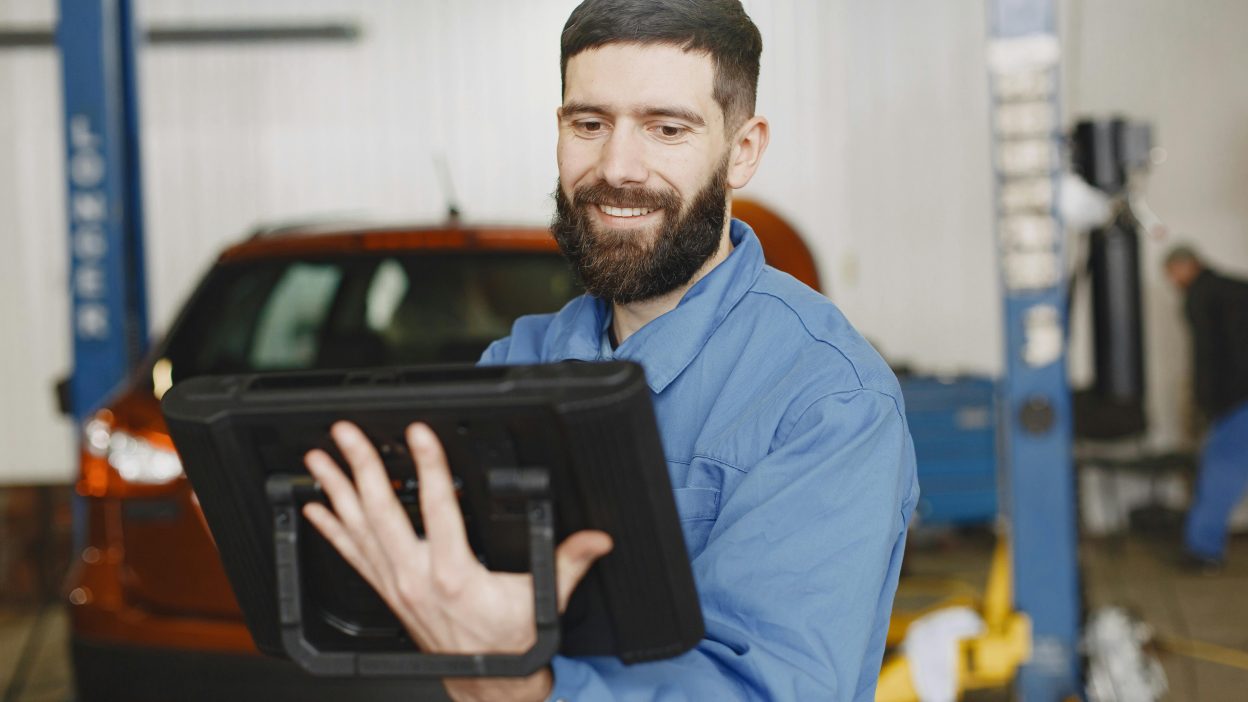 mechanic using tablet for auto repair shop software comparison