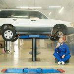 mechanic using smartphone for digital vehicle inspection in auto repair shop